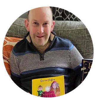 AAC user Gavin with the book he has authored.