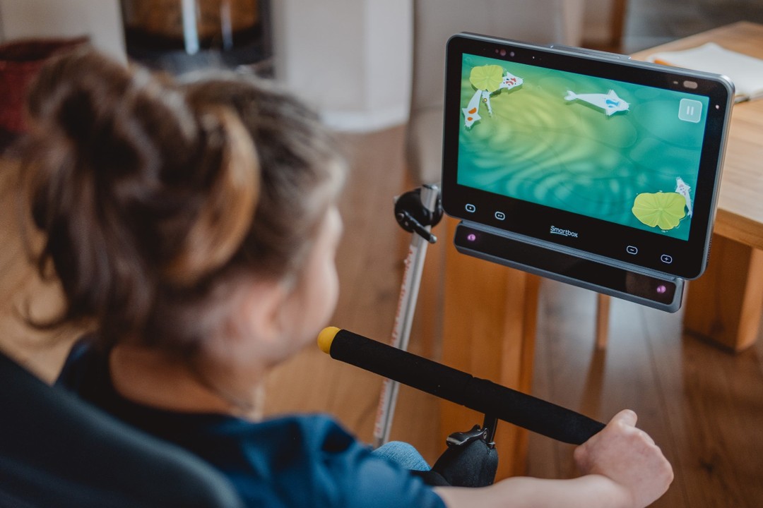 A lady looking at her Grid Pad with a Vida eye tracker