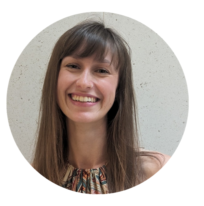 Headshot of Alyssa smiling with a light grey, speckled back drop.