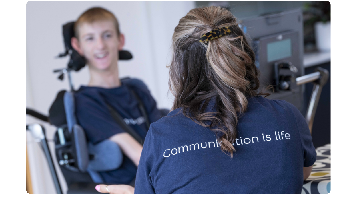 Samuel smiling with his Evo, engaging with a lady seated opposite him.