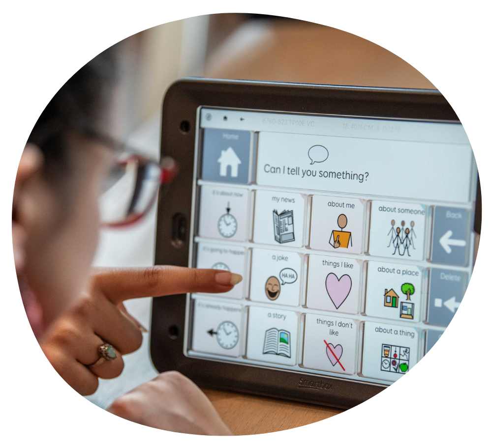 Image of Sufina using her touch screen Grid Pad that displays the message