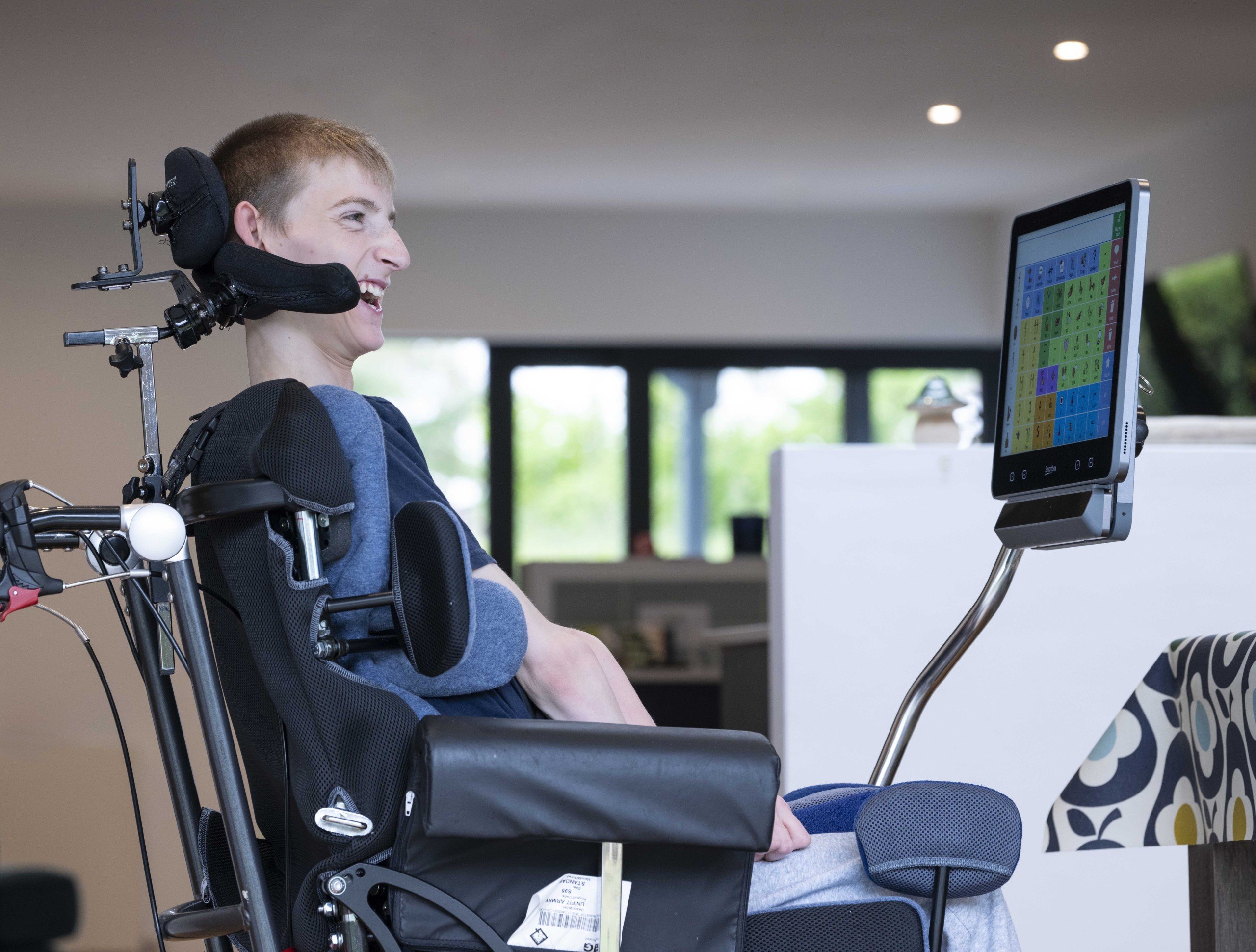 Samuel smiling  at home, using his Grid Pad 16 with Evo