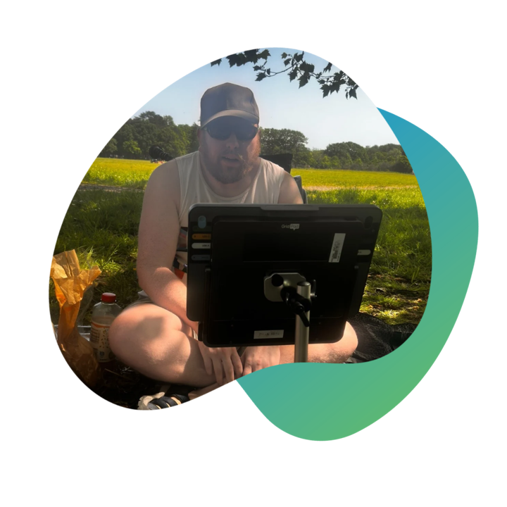 Oliver seated outdoors with his Grid Pad and Evo