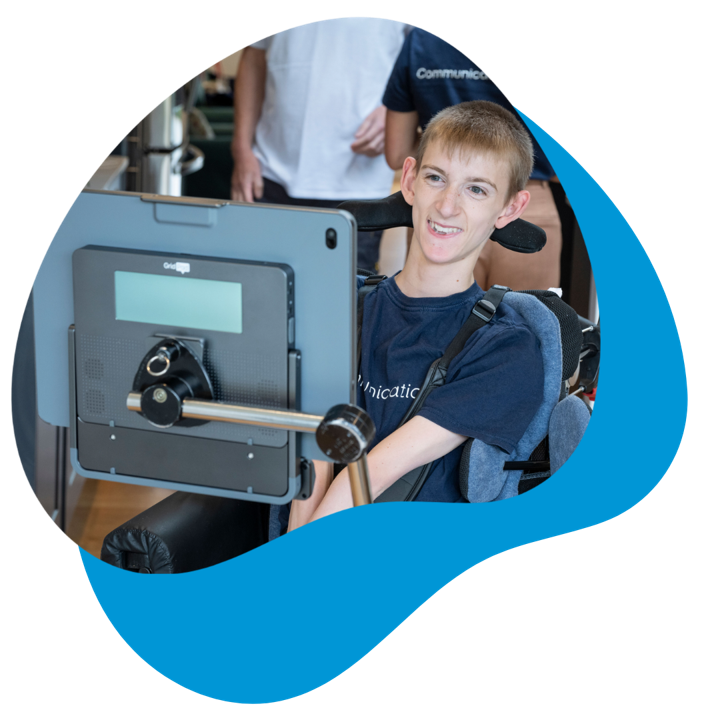 Grid Pad user, Samuel, sitting in his wheelchair smiling.