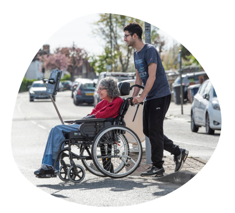 Sarah with her son crossing the road (pushing her in her wheelchair)